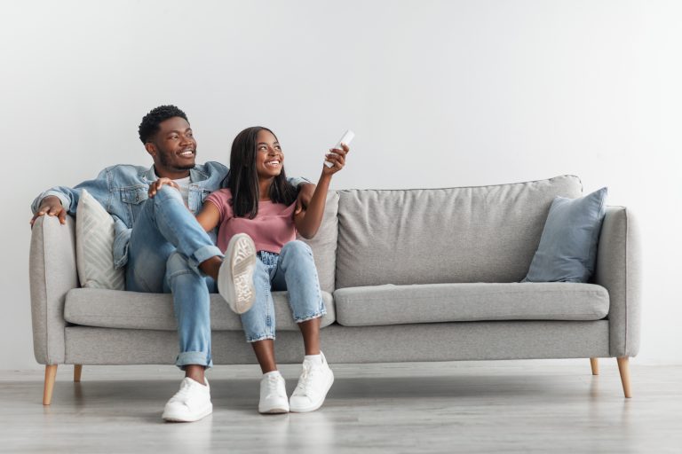 young black woman switching on air conditioning at home