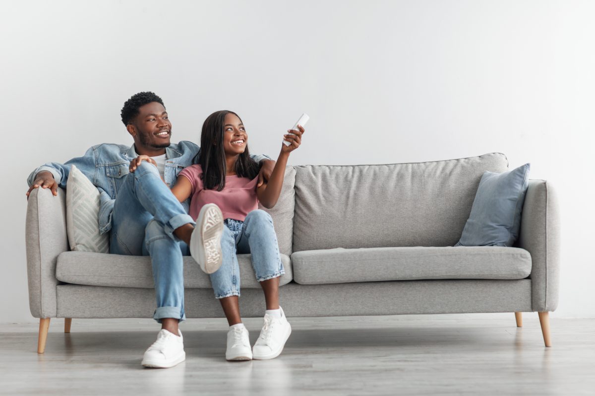 young black woman switching on air conditioning at home